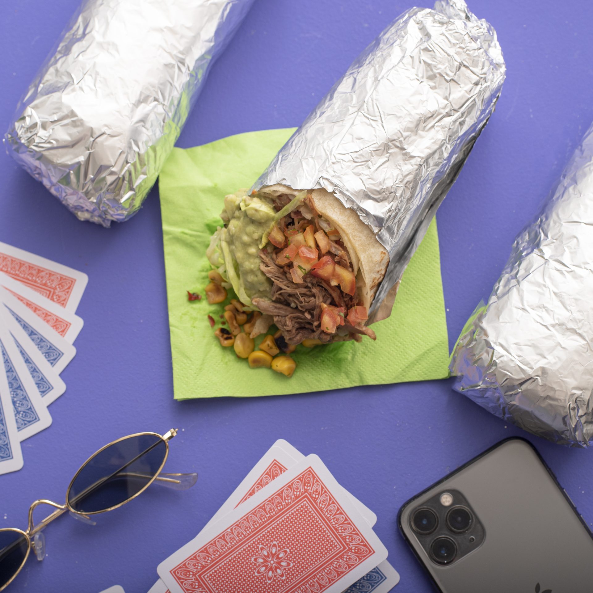 Burritos One Burrito sobre fondo morado con cartas y gafas
