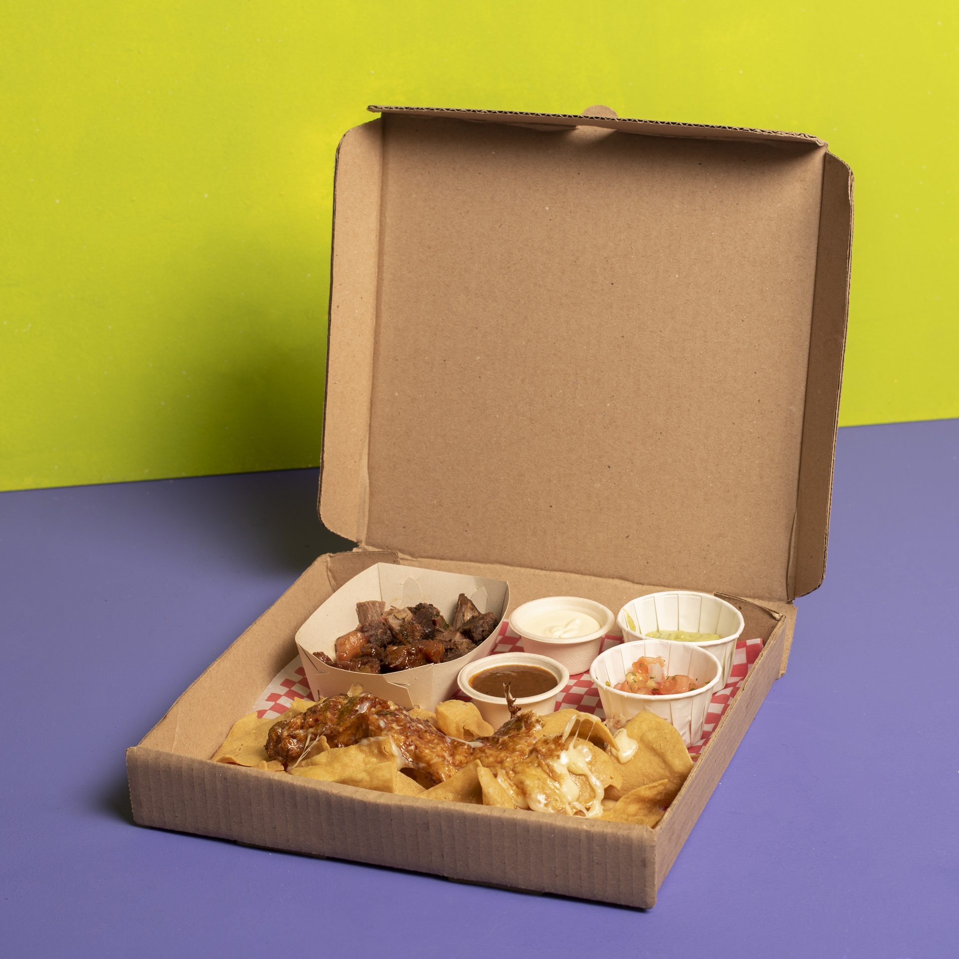 Nachos en caja sobre fondo verde y morado